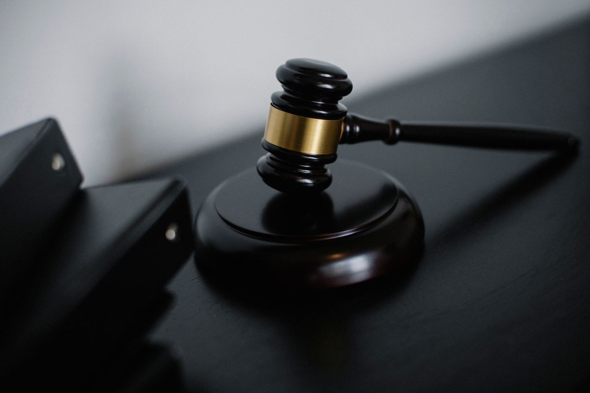 An auctioneer's gavel resting on a sound block